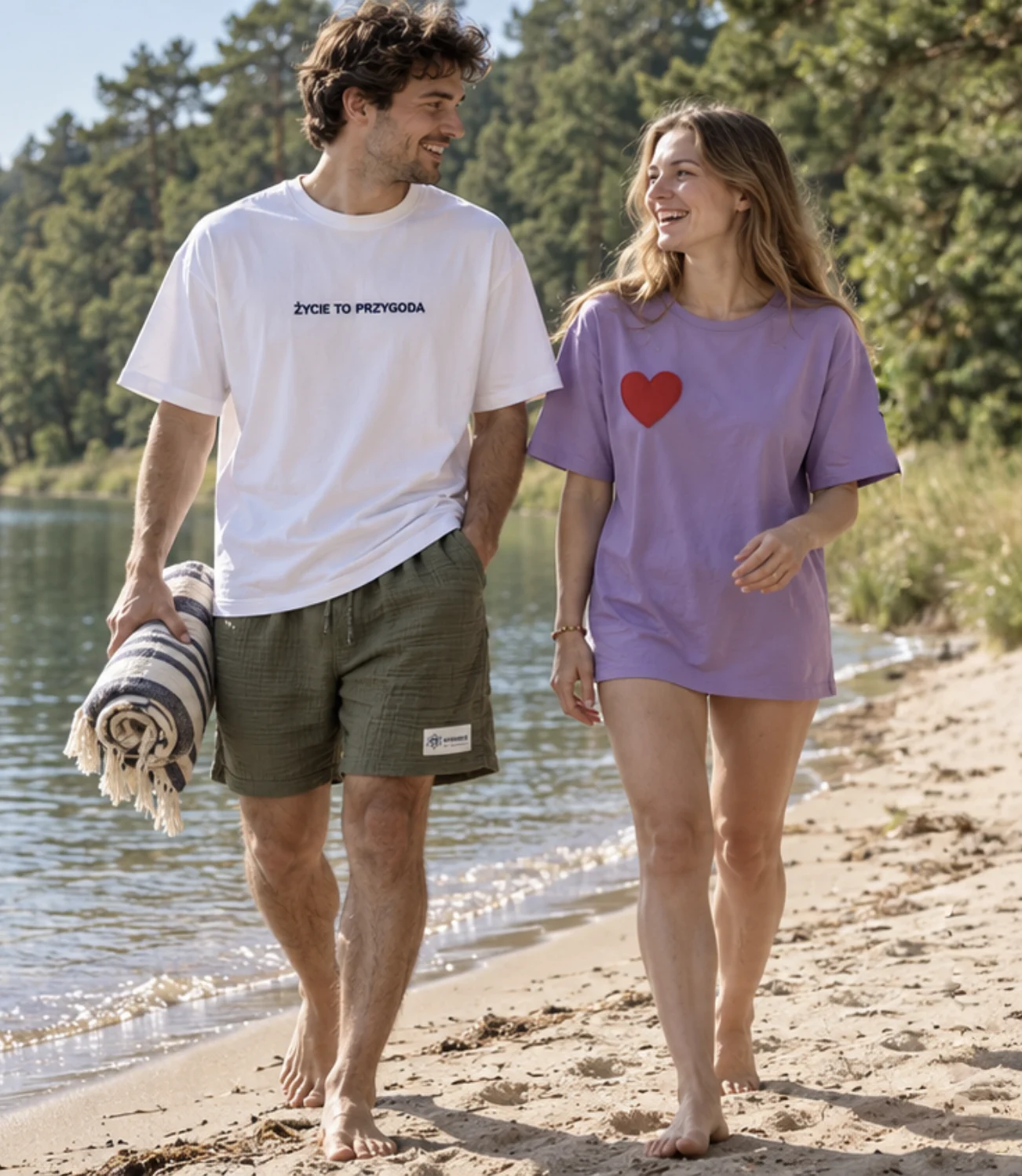 Kobieta w fioletowym t-shircie z sercem noszonym jako sukienka, spaceruje po plaży